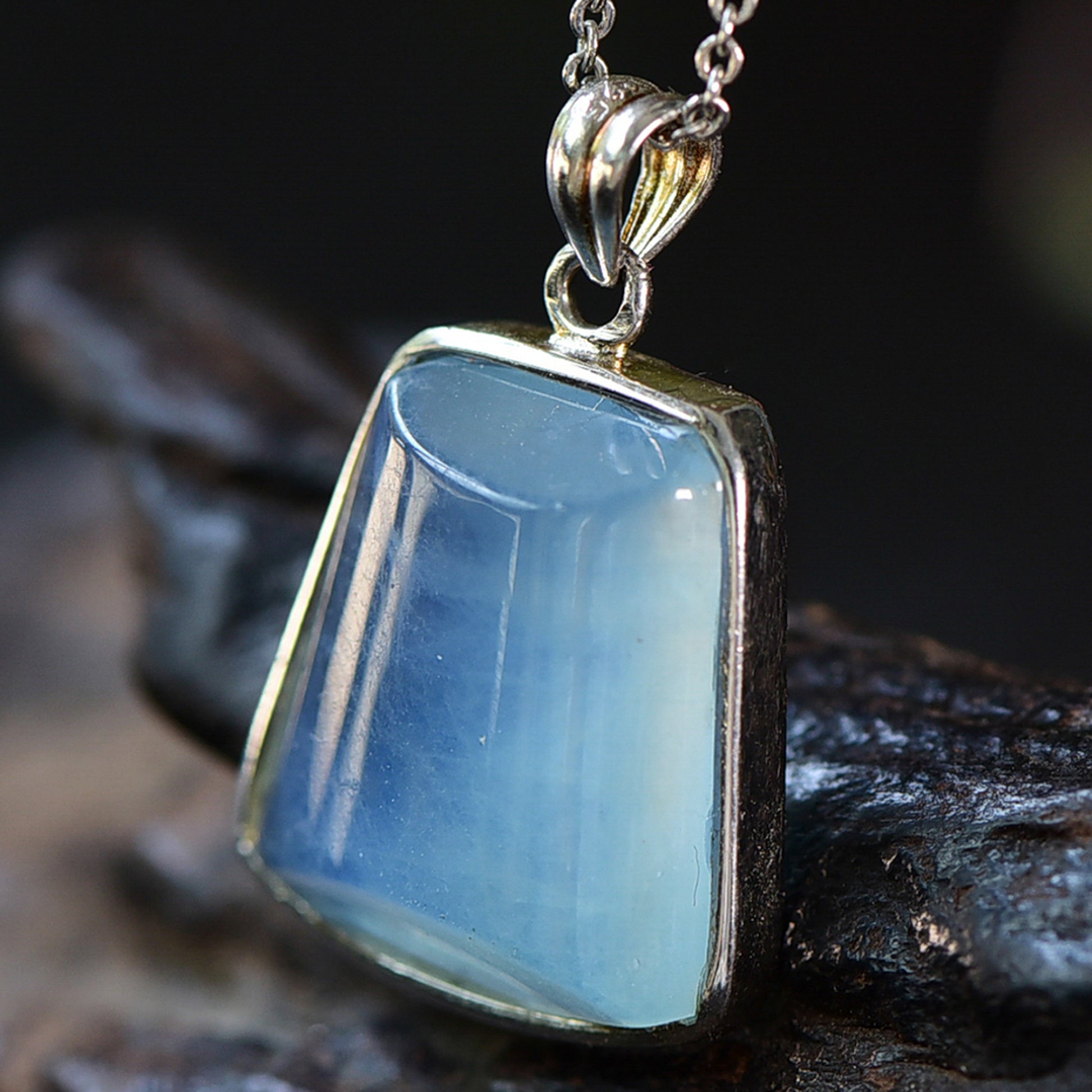 An aquamarine stone necklace visible from the right side